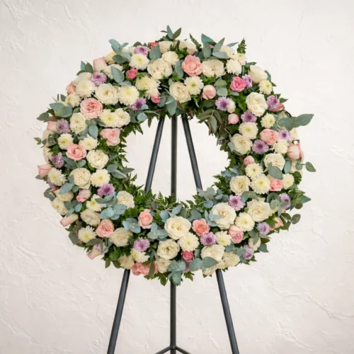 Corona fúnebre con flores moradas y blancas. Elegante para mujer