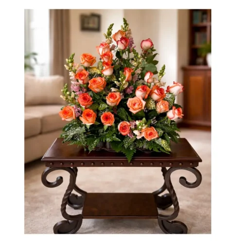 Arreglo floral voluminoso con rosas color coral y naranja. Tonos cálidos y alegres para sorprender.
