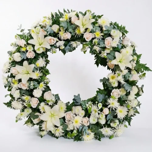 Corona fúnebre grande con lirios blancos y rosas para velación en Guatemala.