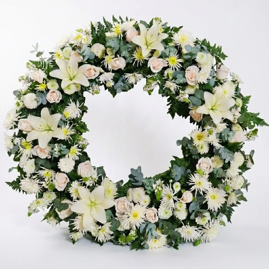 Corona fúnebre grande con lirios blancos y rosas para velación en Guatemala.