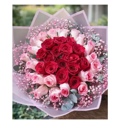 Diseño floral bicolor con corazón de rosas rojas rodeado de rosas rosadas.