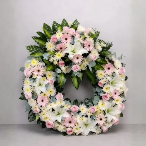 Corona fúnebre rosada y blanca con flores para funeral en Guatemala