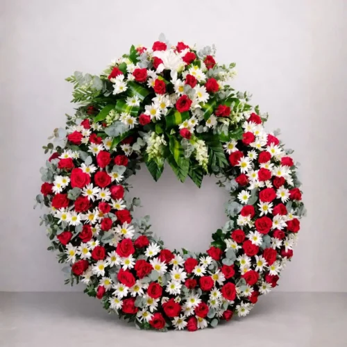 Corona fúnebre con rosas rojas y margaritas blancas para velorio en Guatemala