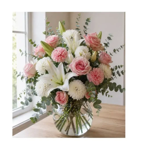 Arreglo floral Luz de Primavera en florero de vidrio con lirios blancos, rosas rosadas, crisantemos y eucalipto en Guatemala.